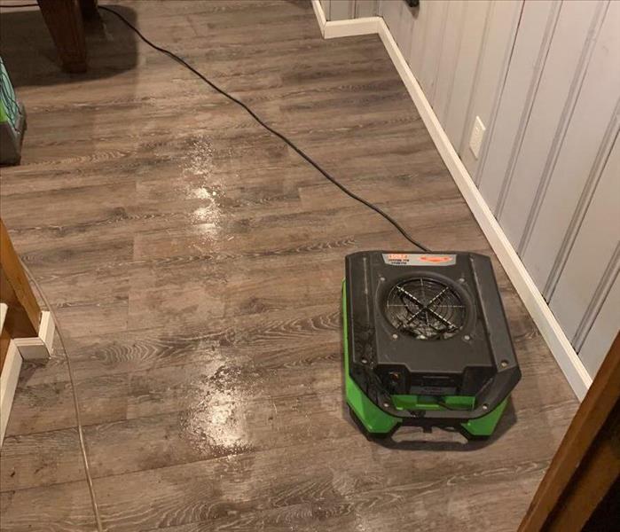 small air mover in a den drying water off the floor